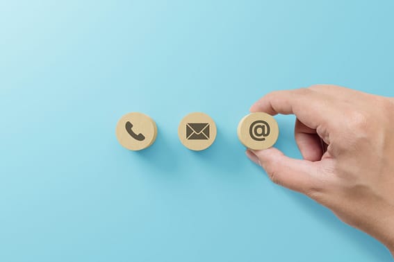 Hand putting wooden block with symbol telephone, email, address. Website page contact us or e-mail marketing concept